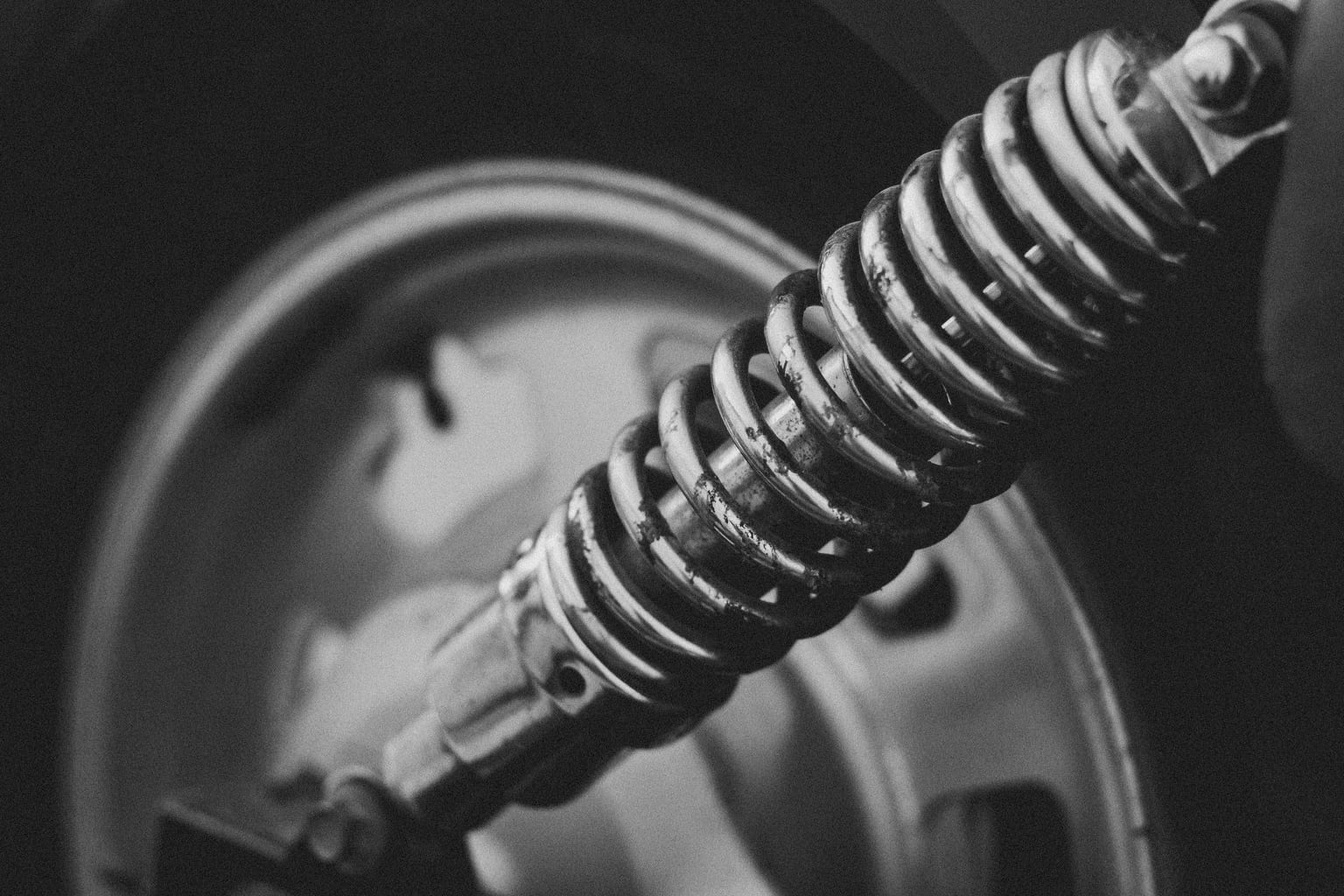 Close-up of a coil-over shock absorber mounted beside a car wheel