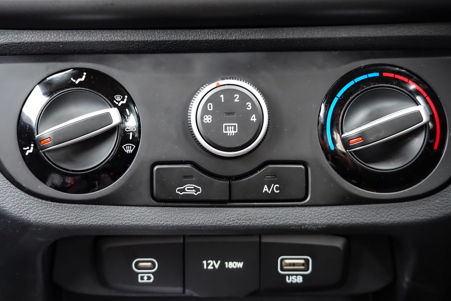 Car climate control panel with the A/C button, fan speed and temperature dials