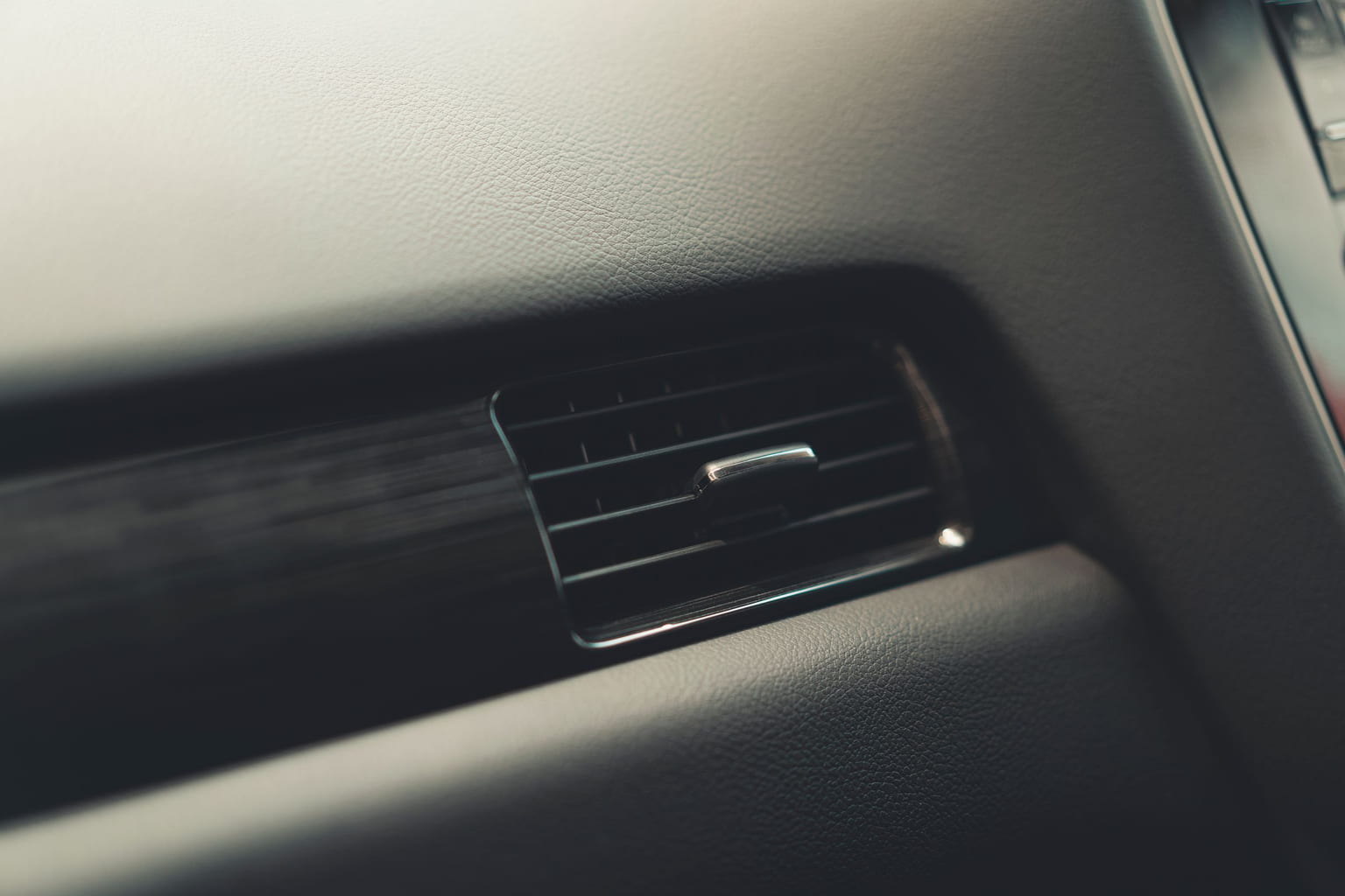 Close-up of an air conditioning vent in a car dashboard