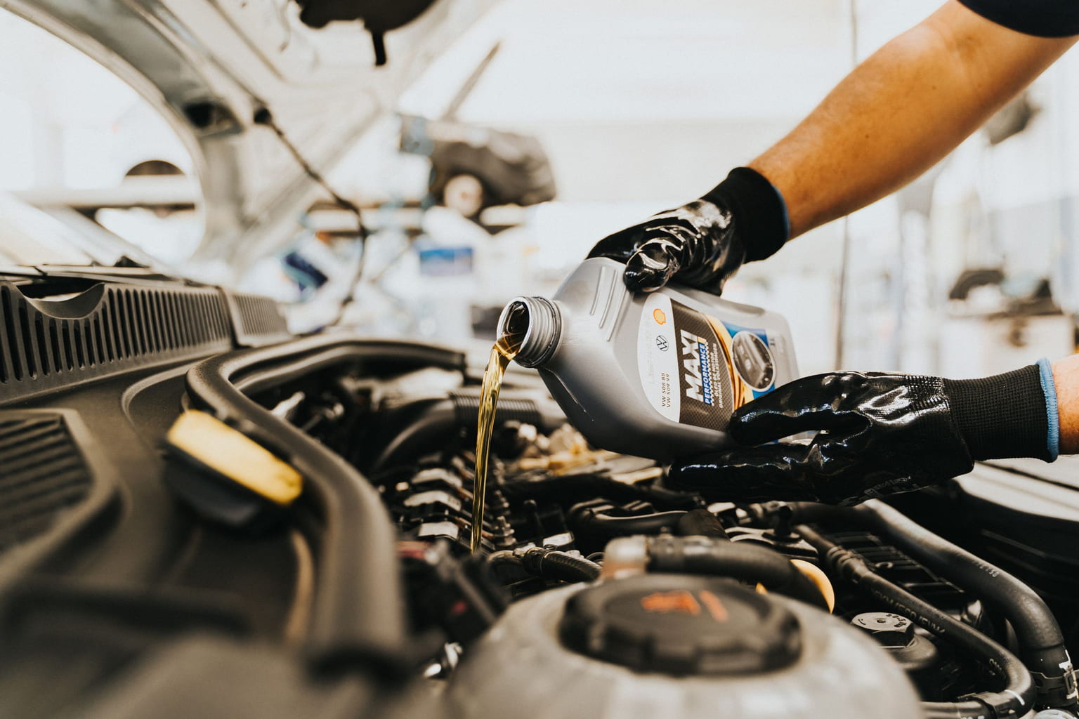 Mechanic pouring engine oil into a car engine