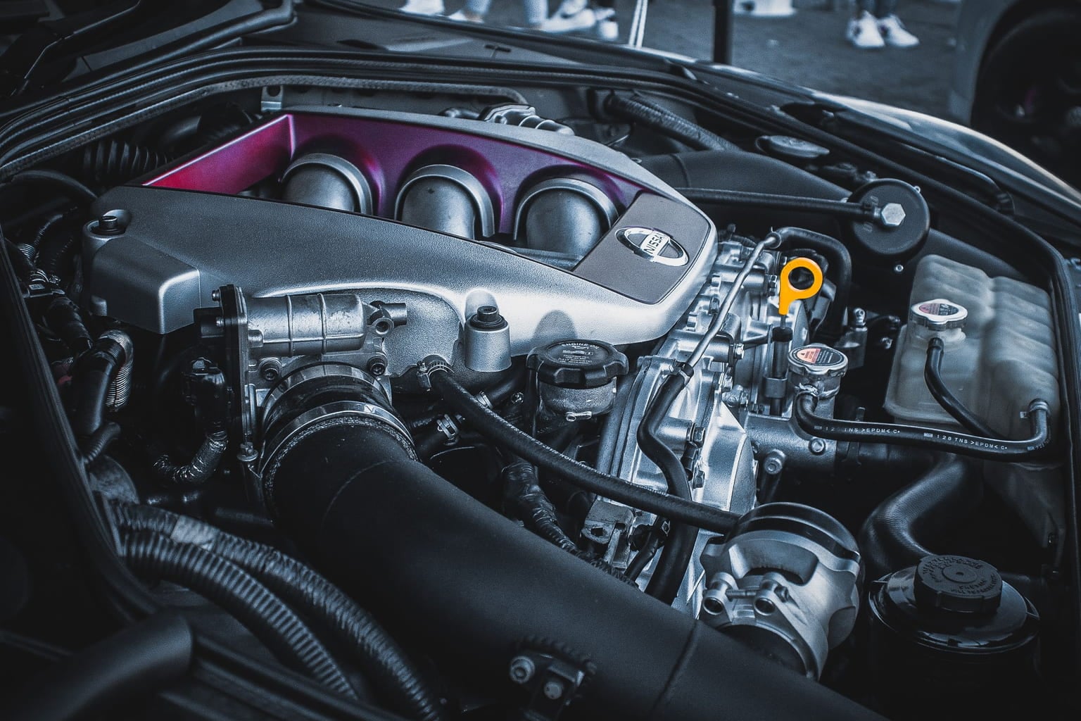Close-up of a car engine bay with the intake plenum and hoses visible