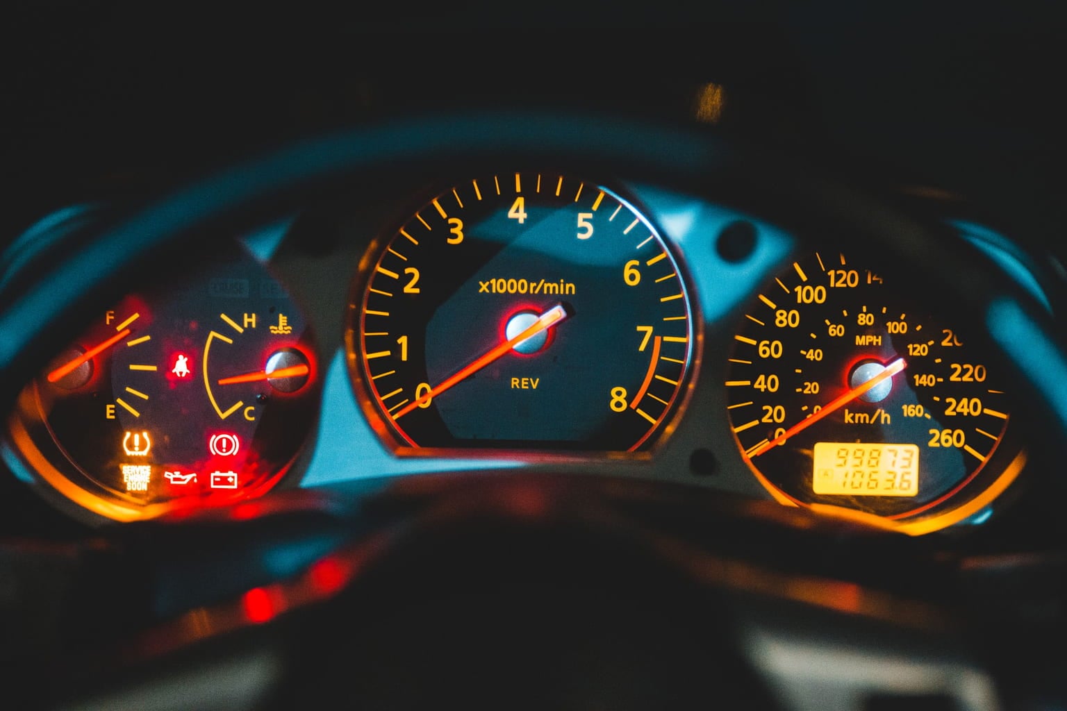 Illuminated car dashboard gauges, including the oil pressure gauge and warning lights