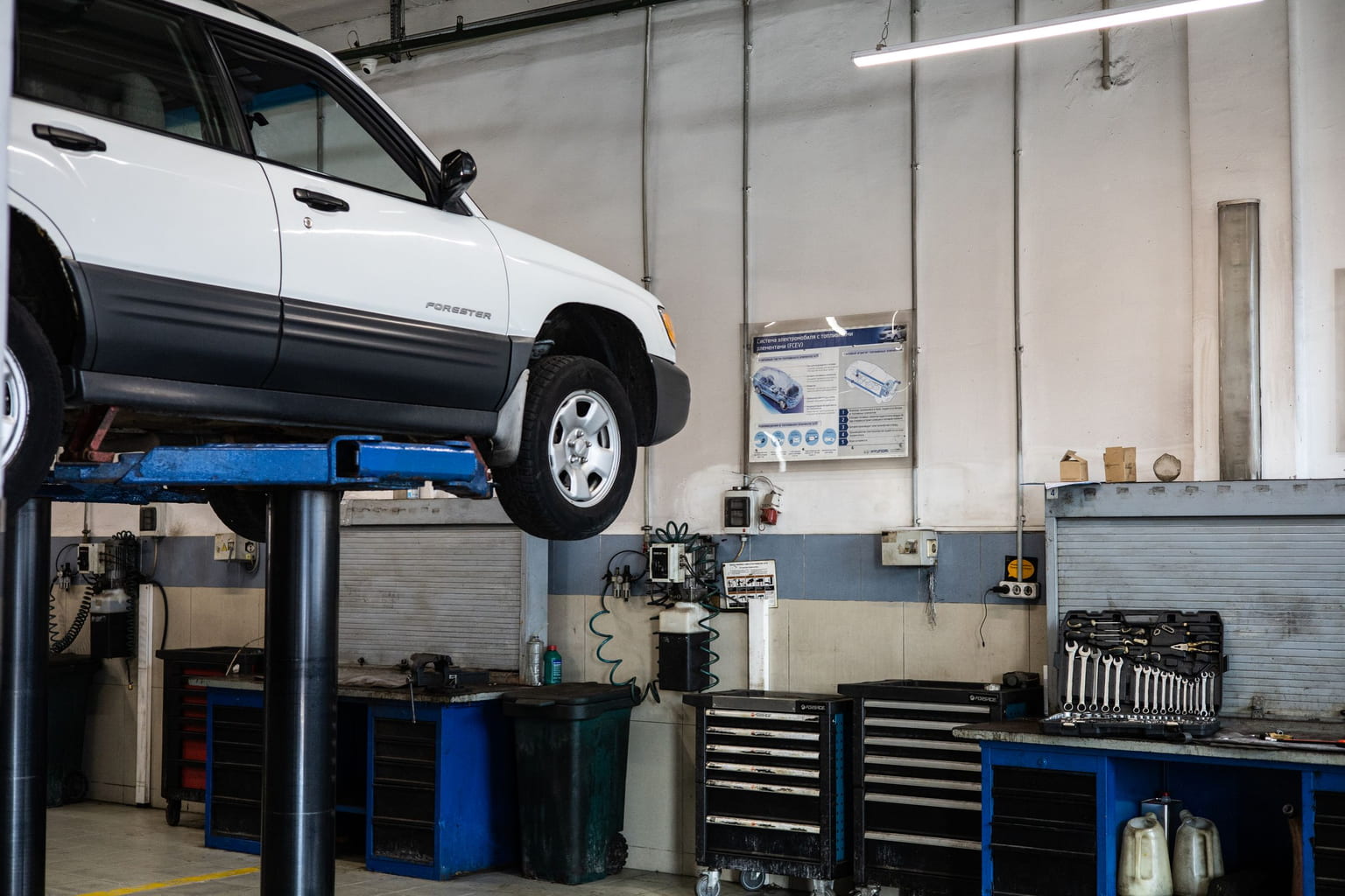 White SUV raised on a lift in a repair shop for service