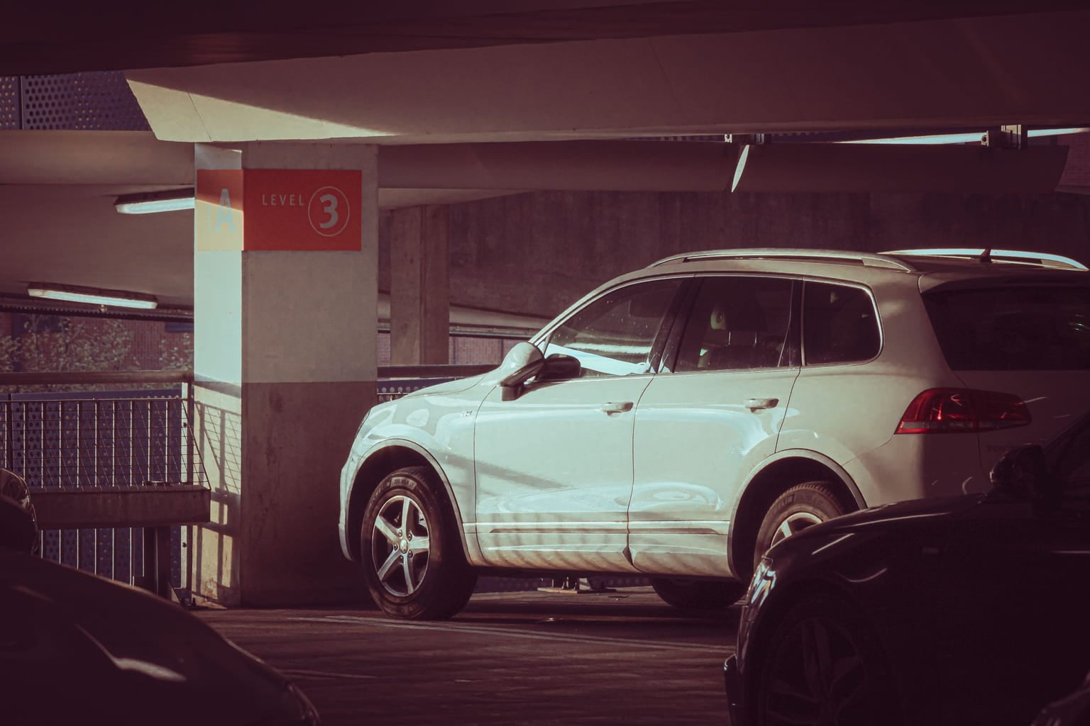 White SUV parked on level 3 of a multi-storey parking garage