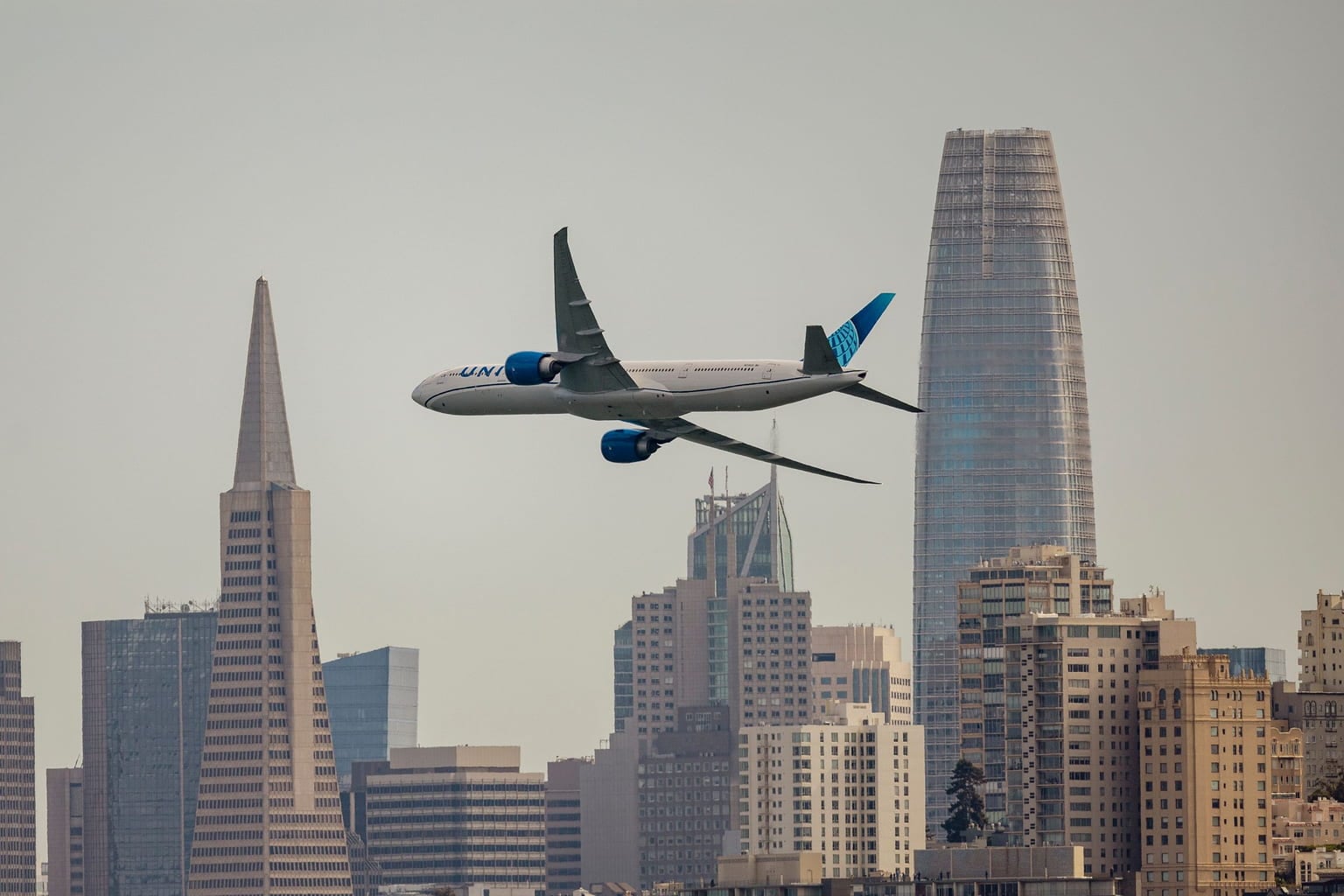 Passenger jet flying past the San Francisco skyline
