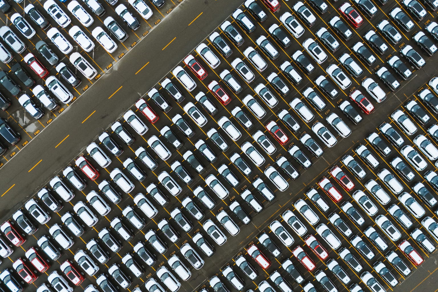 Aerial view of hundreds of cars parked in diagonal rows