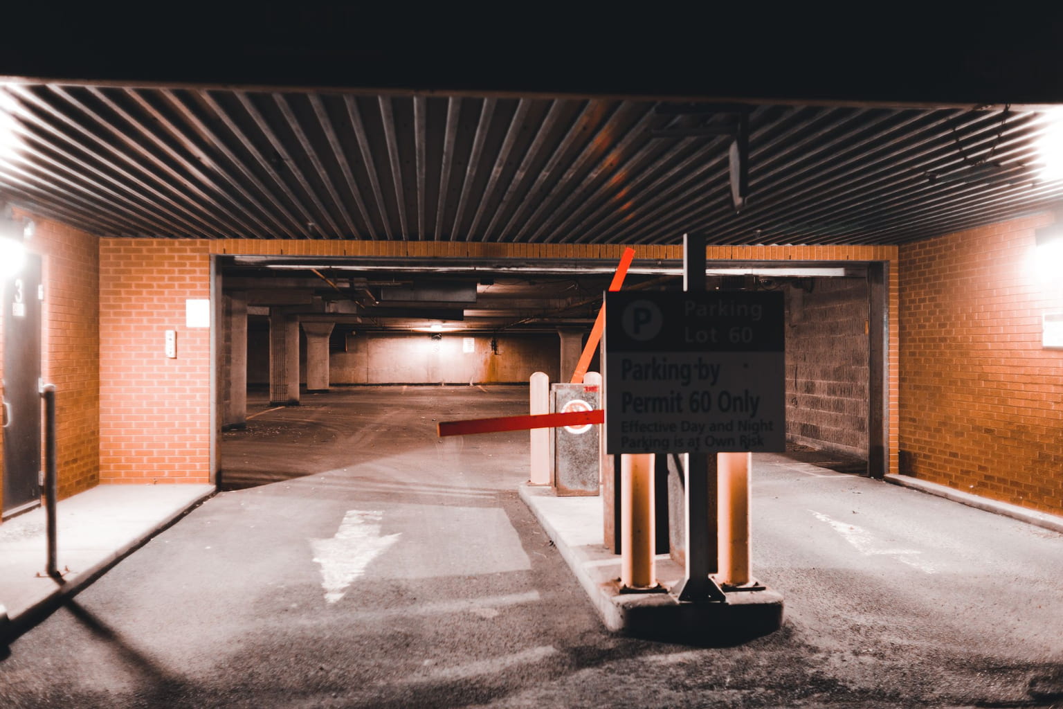 Parking garage entrance with a barrier arm and a ticket machine