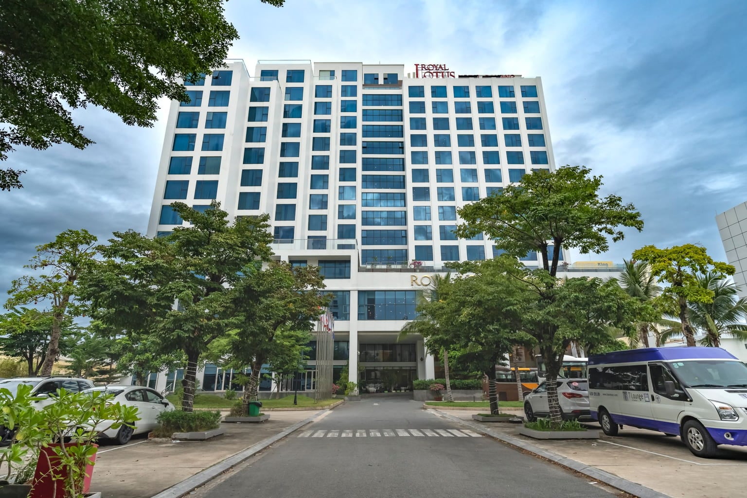 Hotel tower with a white passenger van parked in its driveway